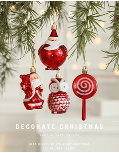Close-up of festive Santa and owl ornaments hanging on green pine branches with bokeh light