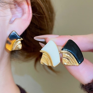 Detail of 18k gold plated geometric resin earrings in ivory white, black and tortoiseshell