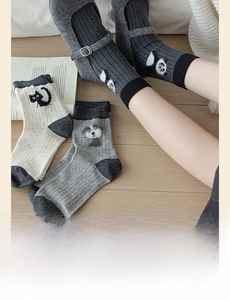 Detail of knit socks with cute animal embroidery featuring panda, cat, and dog patterns