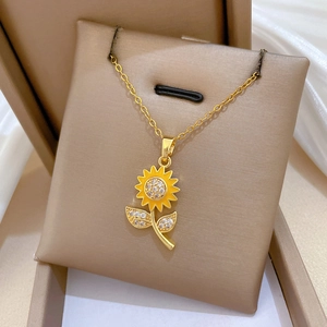 Close-up of golden sunflower pendant with sparkling crystals and yellow enamel detailing
