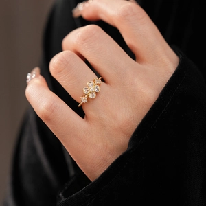 Macro detail of gold flower ring with heart-shaped cubic zirconia and beaded band