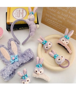 Detailed view of plush purple rabbit hairband and bow clips in a cozy French style setting