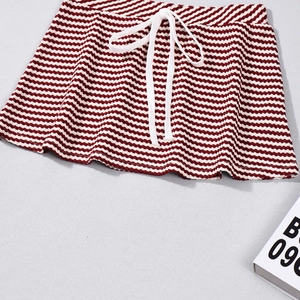 Dettaglio gonna in maglia a righe rosse e bianche con motivo a onde e coulisse in vita