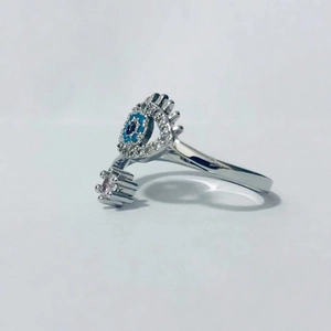Detalle de anillo abierto de ojo turco plateado con piedra azul y circonitas blancas