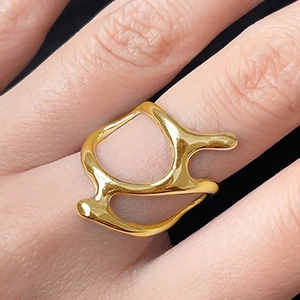 Macro shot of liquid metal style gold ring with irregular hollow melt design