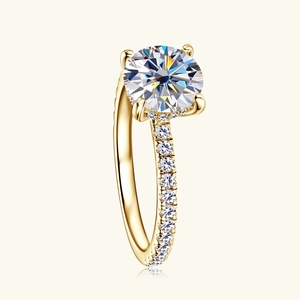 Elegant 18K gold 2 carat moissanite engagement ring with four-prong setting and pavé band