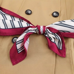Classic double-breasted trench coat with striped silk scarf accessory for women