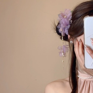 Détail d'une pince à cheveux fleur en tissu violet avec glands en perles et cristaux