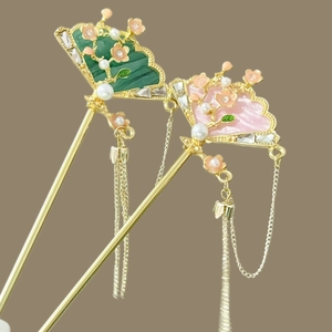 Dettaglio di forcine a ventaglio con decori floreali, perle e lunghe nappe in metallo