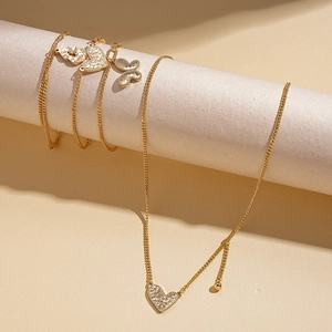 Golden necklace and bracelet set with hammered heart and butterfly charms on display
