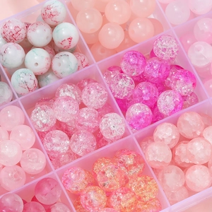 Close-up of pink glass beads in a compartment box for DIY jewelry making and necklaces