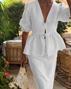 Detail of white V-neck linen set with double front ties and ruffled lantern sleeves