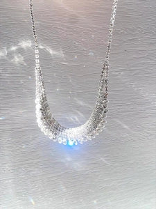 Macro shot of silver tassel necklace with multi-row rhinestones and cascading diamond fringe
