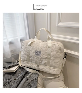 Close-up of star-quilted travel bag with independent bottom shoe compartment in beige