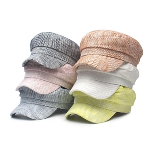 Close-up of stacked colorful textured woven newsboy caps in various vibrant colors