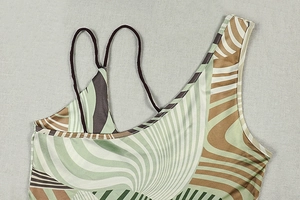 Detail eines Bodysuits mit abstraktem Wellenprint, dünnen Doppelträgern und besonderem Ausschnitt
