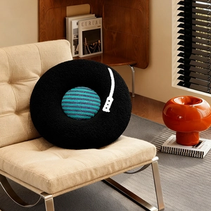 Creative vinyl record round plush pillow with soft texture on a modern beige chair