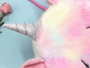 Détail de la peluche arc-en-ciel et de la corne à paillettes argentées du sac licorne