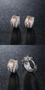Macro shot of silver drop earrings with orange gemstone and crystal pavé details