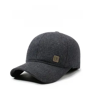 Detail of dark grey wool blend winter baseball cap with vintage metal logo plaque
