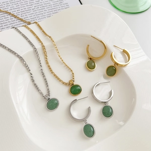 Detailed close-up of green aventurine stone necklaces and earrings in gold and silver