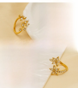 Detail of gold-plated stainless steel rings with zircon leaves and floral patterns