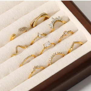 Close-up of gold titanium steel rings with cubic zirconia in a white velvet jewelry box