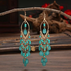 Macro detail of Bohemian tassel earrings with teal beads and water-drop crystal pendants