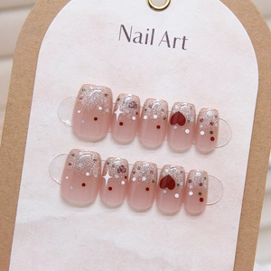 Cat eye press-on nails with heart and polka dot patterns in pink glitter gradient