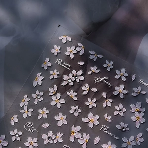 Detail of white flower nail art stickers with crystal rhinestones and yellow centers