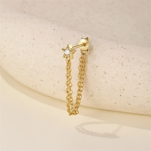 Macro detail of gold S925 sterling silver star earring with tassel chain and zircon stone