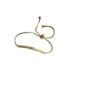 Adjustable golden titanium steel bar bracelet with LOVER DREAM engraving on white background