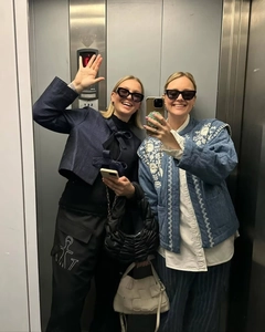 Detail view of retro denim jackets with embroidery on models in a mirror selfie