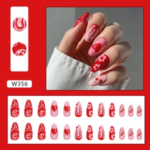 Detailed view of stylish red and pink press-on nails with heart and cherry patterns