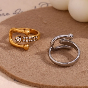 Dettaglio di anelli a fibbia in oro e argento con strass su base di feltro