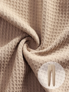 Detailed close-up showing the waffle knit texture and soft fabric of men's beige joggers