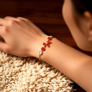Détail du bracelet plaqué or avec breloque animal en émail rouge et cristaux