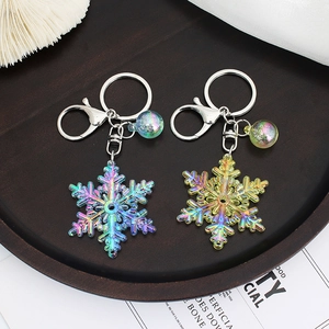 Colorful acrylic snowflake keychain with gradient bubble ball charm on a wooden tray