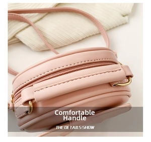 Detail of comfortable pink handbag handle with neat stitching and gold metal D-ring