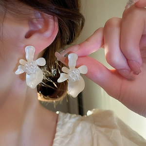 Macro shot of white flower earrings with pearl cluster on silver needles