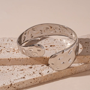 Vista macro del bracciale aperto argento geometrico con finitura martellata su pietra