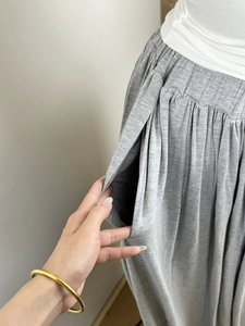 Detailed view of side pockets and pleated elastic waistband on a gray casual skirt