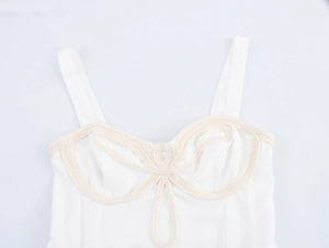 Dettaglio del corpino bianco con decorazione floreale in corda intrecciata beige