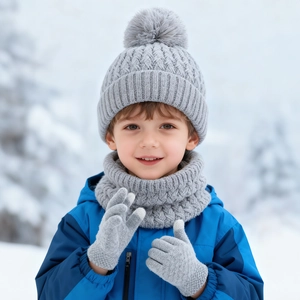 Detailed knit pattern on gray winter set including pom-pom hat, scarf, and gloves