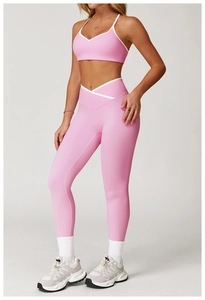 Detail van roze yogaset met witte contrasterende bies en hoge V-vormige crossover taille