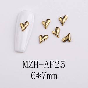 Detail of 6x7mm vintage gold heart nail art charms on white artificial nails