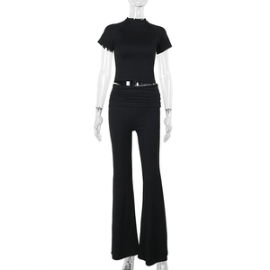 Dettaglio del crop top nero a maniche corte e del set di pantaloni a zampa coordinati