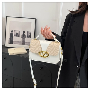 Detail of a white leather and woven straw crossbody bag with golden Y clasp