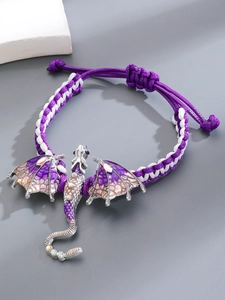 Macro-opname van paars geweven drakenarmband met emaille vleugels en kristallen details