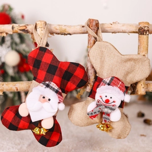 Detail of bone-shaped plaid Christmas stockings with Santa and snowman on a wooden branch